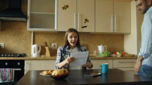 A couple reviews life insurance documents and household finances at a kitchen table.